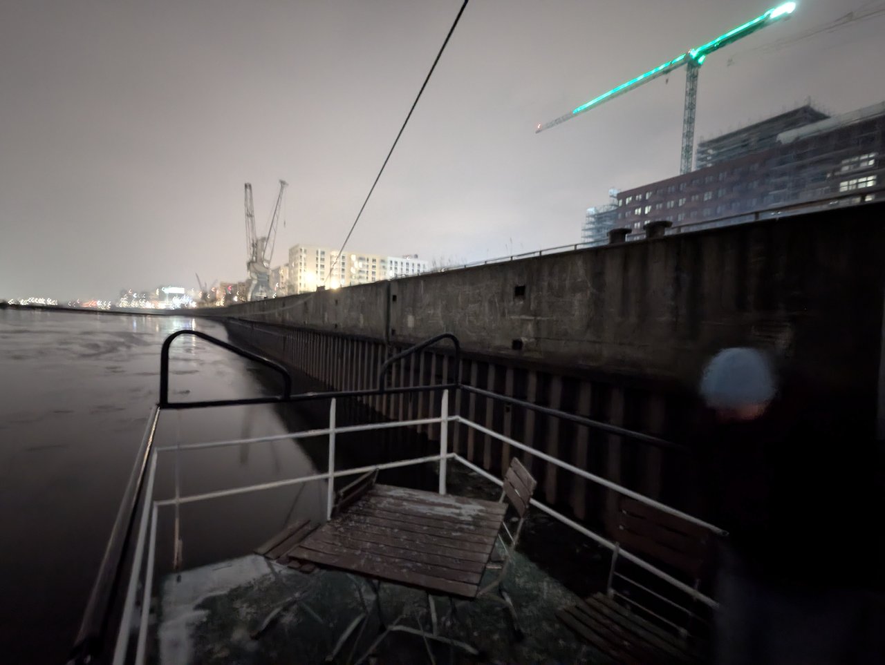 Corner on the ship's deck with a wooden table and a few chairs.